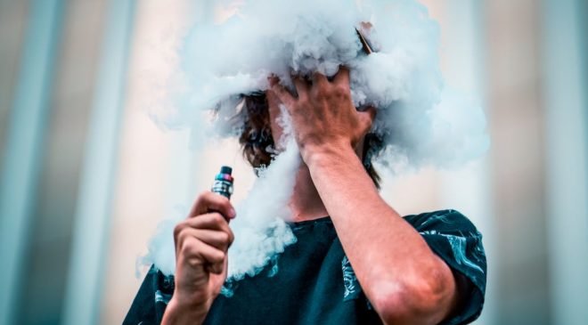 selective focus photography of man doing vape trick